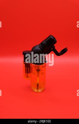 Flüssiges Druckgas in orangefarbenem, durchsichtigem Feuerzeug Stockfoto