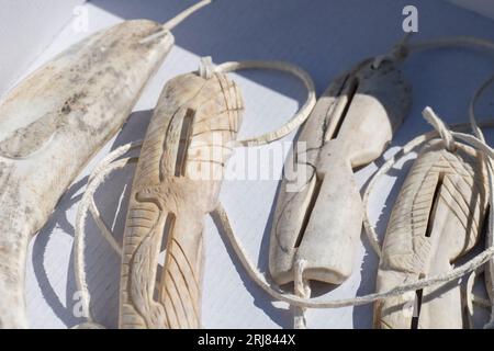 Grönland, Nordwestgrönland, Baffin Bay Area. Traditionelle handgeschnitzte Sonnenbrille und Narwal aus Rentiergeweih. Stockfoto