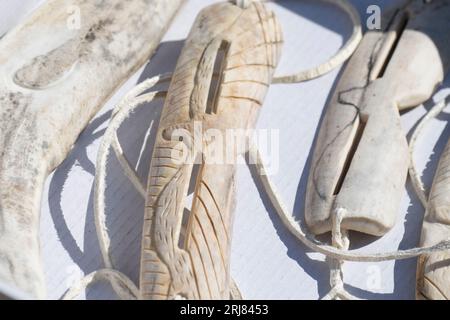 Grönland, Nordwestgrönland, Baffin Bay Area. Traditionelle handgeschnitzte Sonnenbrille und Narwal aus Rentiergeweih. Stockfoto