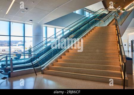 Von unten nach oben Ansicht der allgemeinen Treppen, die mit zwei Rolltreppen auf der linken Seite und dem entfernten Aufzug ansteigend sind Stockfoto