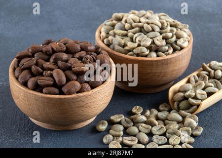 Grüner Kaffee mit gerösteten Kaffeebohnen auf dunklem Hintergrund Stockfoto