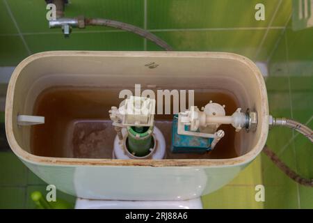 Öffnen Sie die Abdeckung des Toilettenbehälters, und reparieren Sie das Abwasser der Toilette Stockfoto