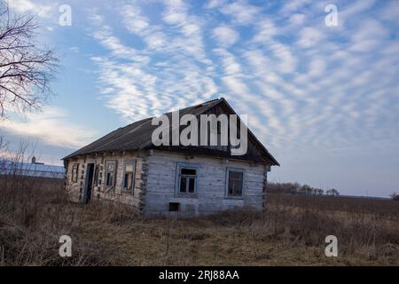 Verlassenes altes Holzhaus im Herbst am Abend Stockfoto