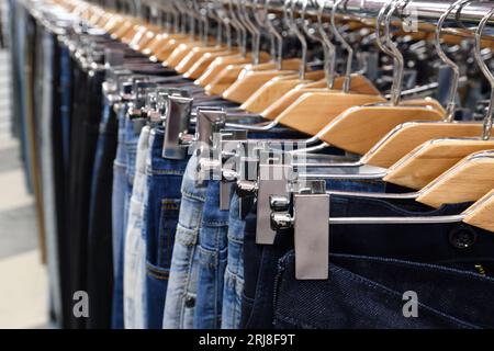 Jeans, die in einem Geschäft am Kleiderbügel hängen Stockfoto