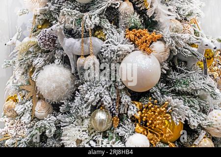 Weihnachtsbaum mit weißen dekorativen Hirschen und Weihnachtskugeln. Weihnachtsstimmung Stockfoto