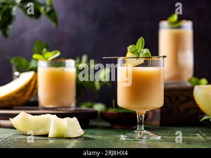 Melonencocktail mit Minze im Glas auf dunkelgrünem Keramikfliesenhintergrund, Nahaufnahme. Getränke im Herbst und alkoholische Cocktails im Sommer. Alkoholischer Cocktail oder Stockfoto