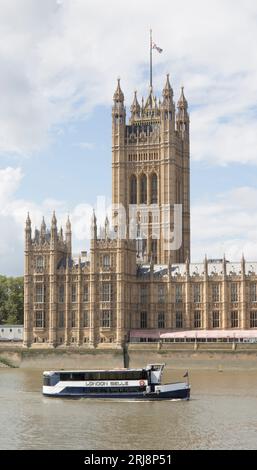 Ein Touristenboot fährt am Victoria Tower Palace von Westminster London vorbei Stockfoto