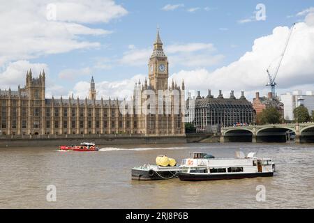 Ein Feuerrettungsboot fährt am Palace of Westminster und der Westminster Bridge River Thames London vorbei Stockfoto