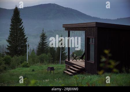 Moderne schwarze Hütte mit Terrasse auf den Karpaten in der Ukraine Stockfoto