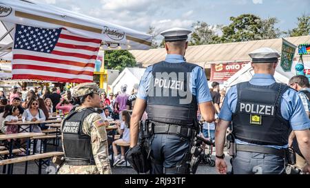 WIESBADEN, HESSEN, DEUTSCHLAND - 07-03-2023- Rücken von zwei deutschen Polizeibeamten und einer amerikanischen Militärpolizistin in kugelsicheren Westen an der Deutschen Stockfoto