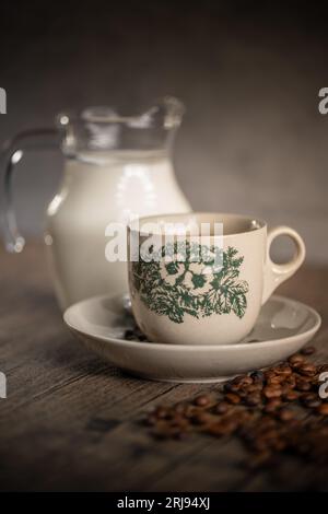 Traditionelle Kopitiam Kaffeetasse aus Porzellan mit Blumenmuster und einem kleinen Glas Milch. Malaysischer Kaffee. Chinesischer Kaffee. Stockfoto