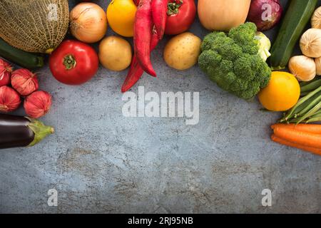 Eine lebhafte Vielfalt an frischem Obst und Gemüse auf grauer Oberfläche. Stockfoto