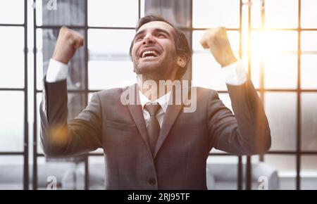 Geschäftsmann in einem modernen Büro, Porträt erfolgreichen Mann, der Sieg und gute Ergebnisse feiert Stockfoto