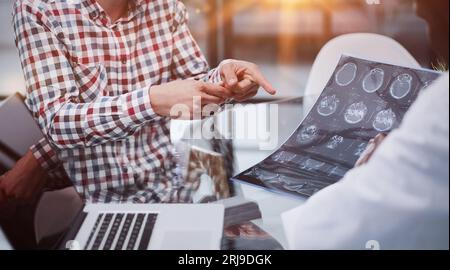 Der Arzt und der Patient an der Rezeption besprechen das Röntgenbild Stockfoto
