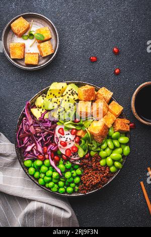 Vegane buddha-Schüssel mit roter Quinoa, gebratenem Tofu, Avocado, Edamambohnen, grünen Erbsen, Rettich, Kohl, Granatäpfel und Sesamsamen mit Sojasauce. Heilen Stockfoto