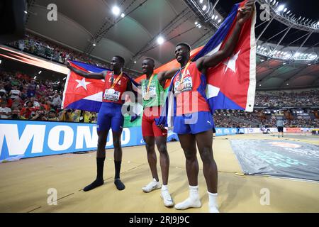 Budapest, Ungarn. August 2023. Goldmedaillengewinner Hugues Fabrice Zango (C) aus Burkina Faso, Silbermedaillengewinner Lazaro Martinez (L) aus Kuba und Bronzemedaillengewinner Cristian Napoles aus Kuba posieren nach dem Dreifachsprung der Männer bei den Leichtathletik-Weltmeisterschaften Budapest 2023 in Budapest, Ungarn, 21. August 2023. Quelle: Li Ming/Xinhua/Alamy Live News Stockfoto