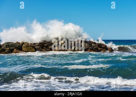 Große weiße Wellen des Meeres brechen auf den Felsen. Wellenbrecher in der Nähe des kleinen Dorfes Framura. La Spezia, Ligurien, Italien, Europa. Mittelmeer. Stockfoto