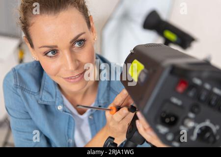 Der Fotograf passt das Blitzlicht im Studio an Stockfoto