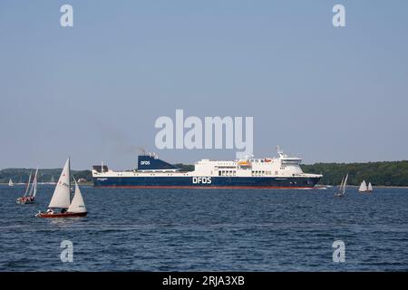 Sailiing-Rennen während der Kieler Woche, im Hintergrund ATHENA SEAWAYS, ein 2007 gebautes Ro-Ro-/Passagierschiff, das unter der Flagge von L segelt Stockfoto