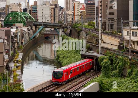 TOKIO, JAPAN - 9. AUGUST 2023: Züge, die an einer vielbefahrenen Kreuzung und einem Tunnel über den Kanda River an der Hijiribashi-Brücke in Tokio, Japan, vorbeifahren Stockfoto