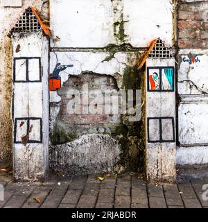 Tiflis, Georgia. Street Art on Vent Shafts: Ein guckender tom beobachtet ein Paar von Liebenden in einem Nachbarhaus mit einem Teleskop. Die Liebenden tragen eine Mundmaske Stockfoto