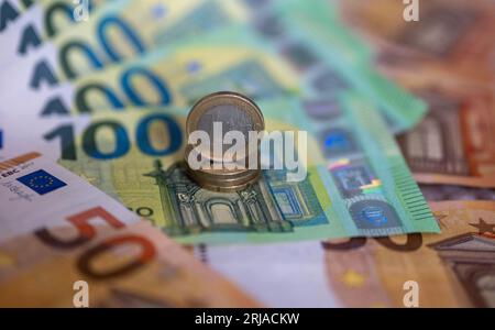 Berlin, Deutschland. August 2023. Banknoten im Wert von 100 und 50 Euro und 1-Euro-Münzen liegen auf einem Tisch. Kredit: Monika Skolimowska/dpa/Alamy Live News Stockfoto