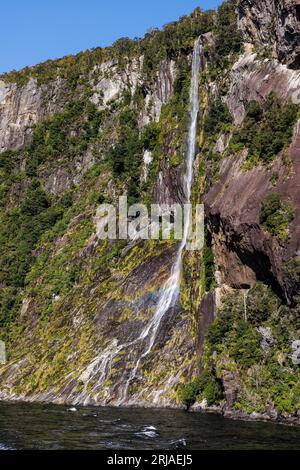 Ein Bild eines kleinen Wasserfalls umgeben von üppiger Pflanzenwelt. Dieses Foto wurde in den Milford Sounds von Neuseeland aufgenommen Stockfoto
