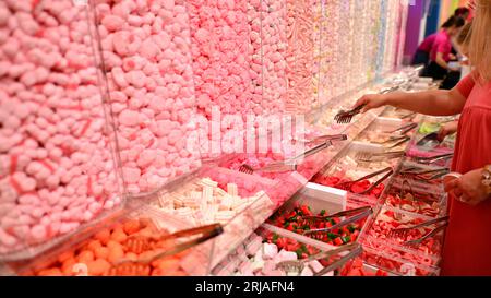 Plastikgläser gefüllt mit bunten Süßigkeiten im Geschäft. Stockfoto