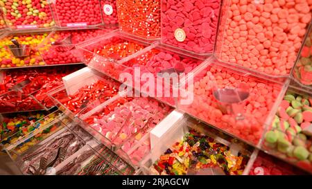 Plastikgläser gefüllt mit bunten Süßigkeiten im Geschäft. Stockfoto