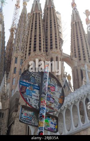 Ein Straßenschild in Barcelona, das mit Aufklebern bedeckt ist und auf einen beliebten Touristenort in der Nähe der Sagrada Familia hinweist. Stockfoto