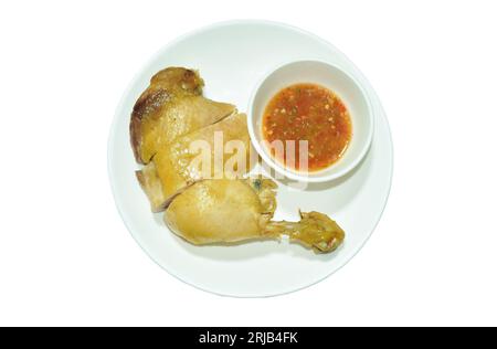 boiled chicken thigh and leg with herb brown soup on plate dipping spicy chili sauce cup Stockfoto