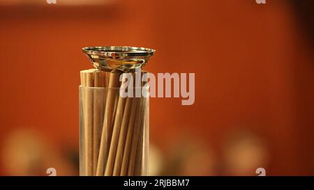 Umweltfreundliche Trinkhalme aus Papier in einem Glas mit Edelstahldeckel. Samtroter Hintergrund in einem Theater. Stockfoto