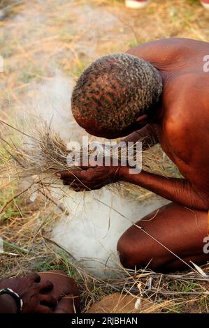 San oder Buschmann Mann, der Feuer durch Reiben auf traditionelle Weise macht. Tsumkwe, Otjozondjupa, Namibia. Stockfoto