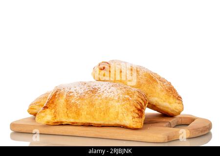 Zwei aromatische Blätterteigbrötchen mit Äpfeln auf einem hölzernen Küchenbrett, Nahaufnahme, isoliert auf weißem Hintergrund. Stockfoto