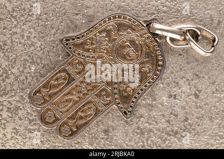 Ein Schlüsselanhänger aus Metall, jüdische Hand von Miriam auf Metall, Nahaufnahme, Draufsicht. Stockfoto