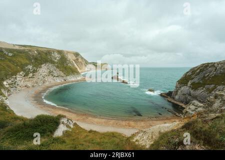 Eine halbmondförmige Meeresbucht, umgeben von einer felsigen Küste und einem Strand an der Dorset-Küste in Südengland. Befindet sich neben Durdle Door. Man O' war Beach. Hochwertige Fotos Stockfoto