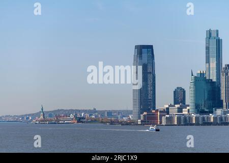 Jersey City, NY, USA, Mai 2022; Blick über den Hudson River in Richtung des hohen Rises von Jersey City, Ellis Island National Museum of Immigration und Statue Stockfoto