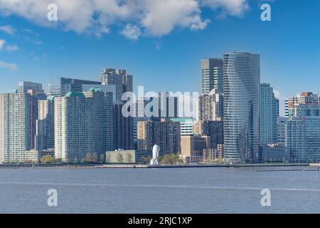 Jersey City, NY, USA-Mai 2022; Blick über den Hudson River in Richtung des hohen Rises von Jersey City mit entlang des Hudson River Waterfront Walkway die Skulptur Stockfoto
