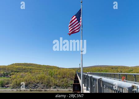 Poughkeepsie, NY, USA, Mai 2022; Seitenansicht des 1,28 Miles Walkway über der Hudson State Historic Park Bridge von 1889 mit amerikanischer Flagge im Vorderfuß Stockfoto