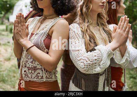 Abgeschnittene Ansicht von Frauen, die gemeinsam im Freiluft-Retreat-Center Gebetsgesten machen Stockfoto