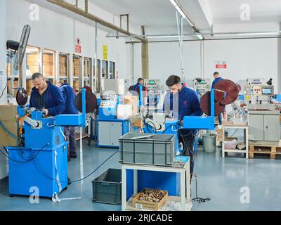 Mitarbeiter, die in einer Etikettendruckerei arbeiten. Der Arbeiter verwendet eine Etikettiermaschine. Aufkleberdrucker. Druckmaschine, die an Etiketten arbeitet. Stockfoto