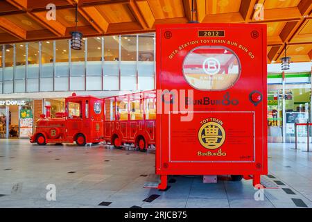 Oita, Japan - November 26 2022: Der berühmte japanische Spielzeugzug, Bun Bun Go, verkehrte in der zentralen Halle des Bahnhofs Oita Stockfoto