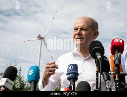 Simmerath, Deutschland. August 2023. Bundeskanzler Olaf Scholz (SPD) spricht zu Journalisten während ihres Besuchs auf einem kommunalen Windpark. Die kleine Stadt mit mehr als 15.000 Einwohnern macht Profite, indem sie das kommunale Waldland an den Betreiber vermietet. Ein Teil der Einnahmen fließt in den kommunalen Haushalt und ermöglicht niedrige Immobilien- und Gewerbesteuern. Quelle: Bernd Thissen/dpa/Alamy Live News Stockfoto