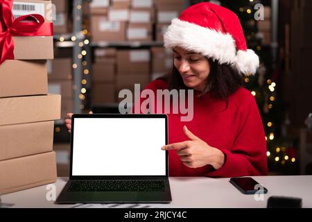 Lagerleiter, der ein Notebook mit leerem Mock-up-Platz verwendet und mit dem Finger darauf zeigt, weihnachtsverkauf, Platz für Ihre Werbung Stockfoto