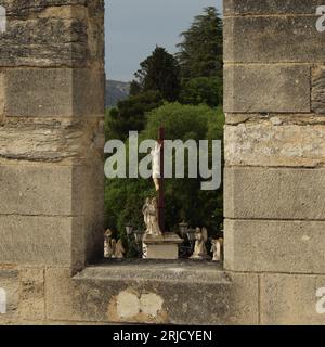 Kruzifix am Place du Palais, Avignon - vom Dach des Palais des Papes durch eine Embrasur, eine Crenel oder eine Crenelle gesehen Stockfoto