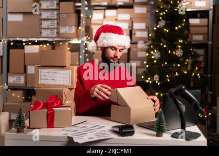 Männlicher Online-Shop Kleinunternehmer Verkäufer Verpackung Paket Post Versandkarton Vorbereitung der Lieferung Paket auf dem Tisch. E-Commerce-Servicekonzept Stockfoto