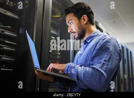 Konnektivität, Rechenzentrum und ein Mann mit einem Laptop für Wartung, Cybersicherheit und Internet-Check. Codierung, E-Mail und ein asiatischer Programmierer, der eingibt Stockfoto