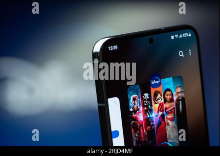 New York, USA - 20. August 2023: Verwendung der Disney plus Service Mobile App auf dem Smartphone-Bildschirm Nahaufnahme mit verschwommenem Logo-Hintergrund Stockfoto
