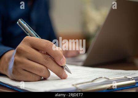 Nahaufnahme eines Geschäftsmannes am Schreibtisch und Unterzeichnung eines Vertrags. Stockfoto