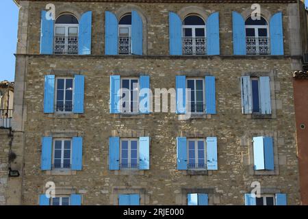 Typische provenzalische Steinfassade mit blauen Fensterläden an jedem Fenster Stockfoto